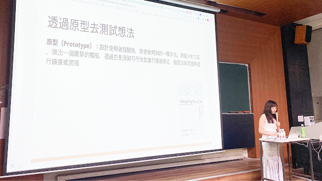 演講現場的側拍，講師正在分享「透過原型去測試想法」的投影片內容